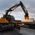 machine lifting barrier onto truck