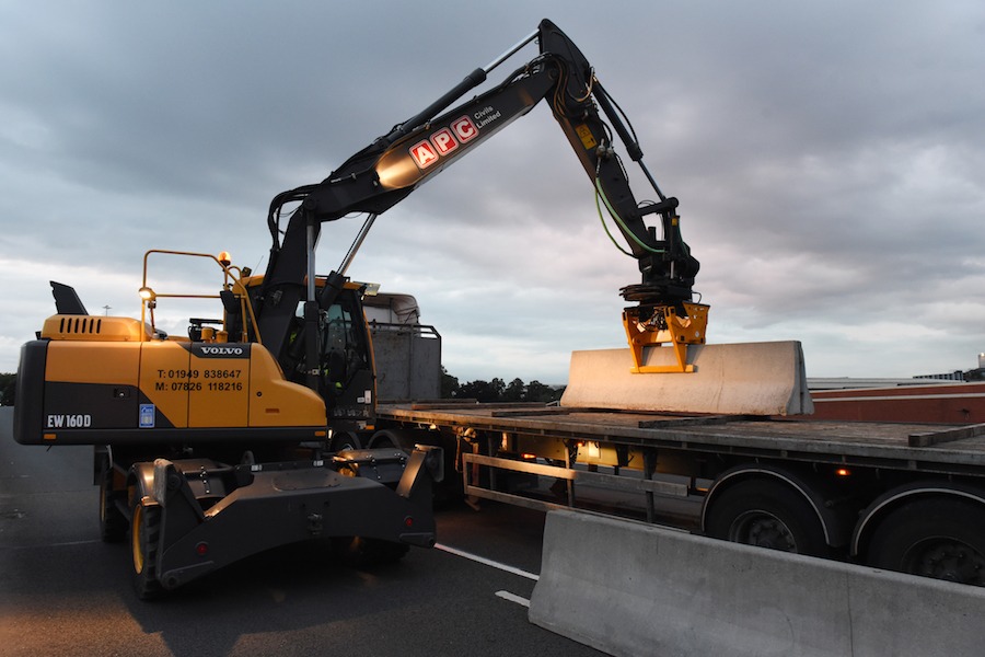 machine lifting barrier onto truck